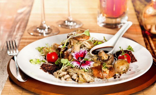 O jardim de cogumelos é a entrada mais famosa do Bistrô Santa Marta. Além dos fungos, leva azeitonas pretas desidratadas e maceradas. Foto: Divulgação.