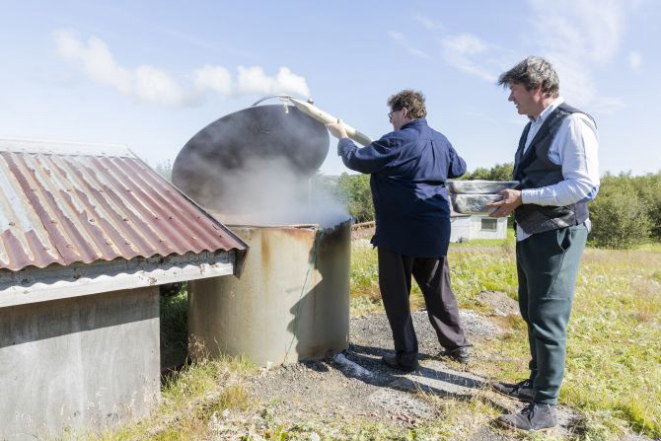 Jon Sigfusson, chef no Fridheimar, e Kjartan Olafsson, um crítico de gastronomia e exportador de peixes, colocam comida dentro de um forno geotermal comunitário. Foto: Bara Kristinsdottir/The New York Times