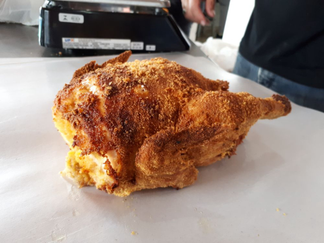 O frango é empanado na farinha de fubá e assado por três horas. Foto: Guilherme Grandi/Gazeta do Povo.