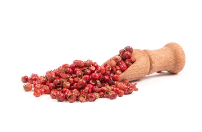 Pink pepper, Red peppercorns in a wooden spoon.