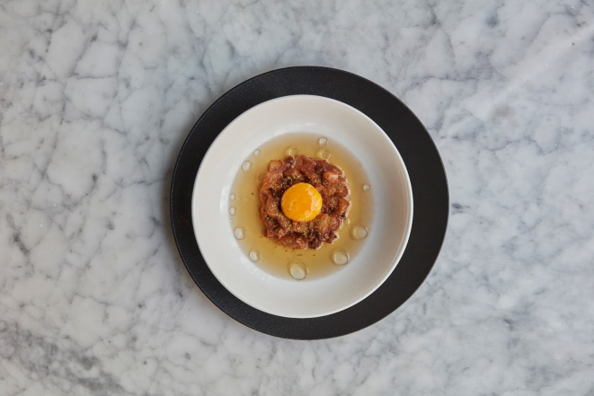 Tartar de pescado, caldo de carne e gema de ovo, prato do restaurante Ambrosía. Foto: Divulgação
