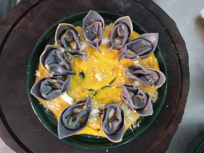 Tortelli com açafrão e sugo de cenoura. A massa fresca leva polpa de jenipapo verde e fica com uma tonalidade arroxeada. Foto: Claudio Oliver/Divulgação
