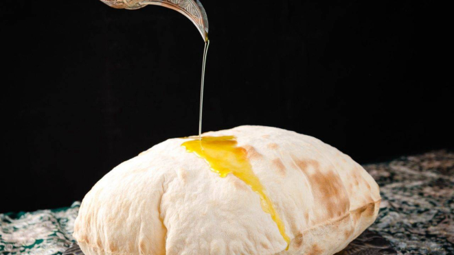 Tudo começa com o delicioso pão árabe, que chega quentinho à mesa.
