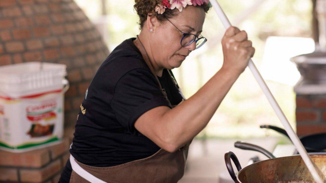 Chef Eva dos Santos, mexendo a comida no tacho.