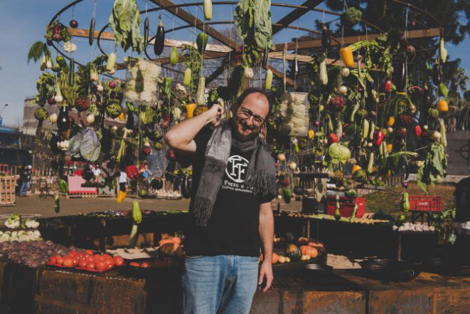 Chef Marcos Livi à frente de seu carrossel de carnes e legumes, onde os alimentos são assados lentamente com as brasas no chão. Foto: Divulgação