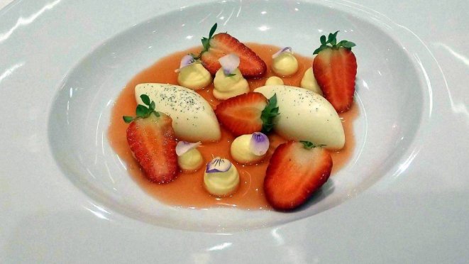 Panna cotta, morangos, calda de morangos e pétalas de amor-perfeito - a sobremesa.