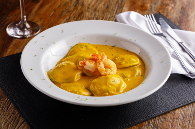 Sorrentini di zucca: massa recheada com abóbora e licor de amêndoas, servida com creme de abóbora, camarões grelhados e raspas de limão, uma das delicias da Cantina Famiglia Fadanelli.