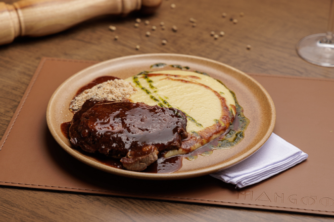 Ancho ao molho demi-glace, com aligot e farofa crocante, no Mangôo.