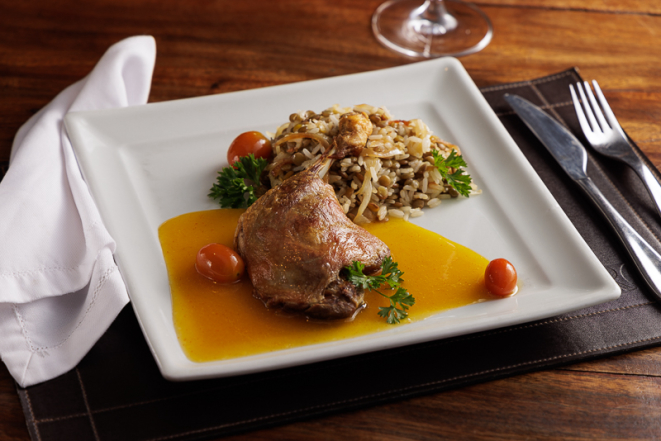 Coxa de pato ao velouté de laranja com arroz de lentilha, cebola caramelizada e tomate-cereja.