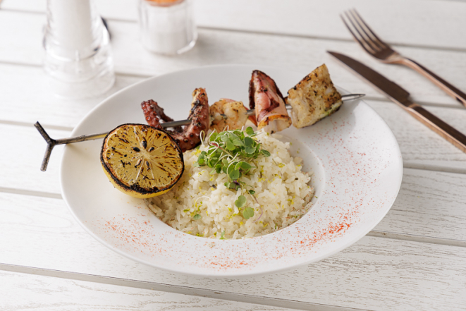 Espeto de polvo, lula, camarão rosa e linguado, acompanhado de risoto de limão-siciliano e limão na brasa, do Ícaro Casual Greek Food.