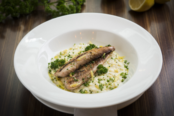 Filé de peixe do dia grelhado acompanhado de risoto de limão- siciliano, finalizado com azeite de ervas, do Paris 6.