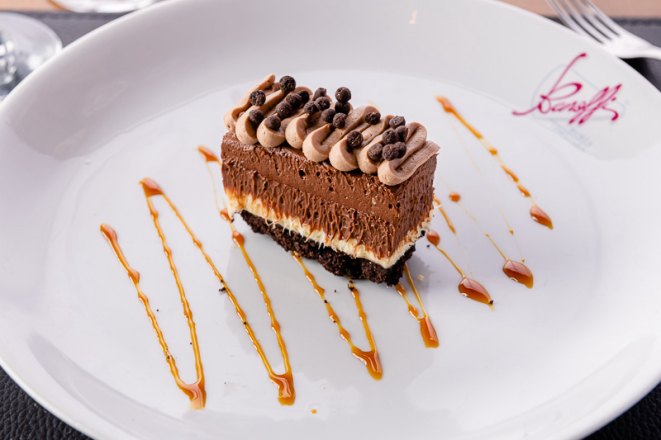 Torta com base de bolacha Óreo, leva mousse de chocolate branco, mousse de chocolate ao leite, mousse de chocolate meio amargo e finalizada com chantilly de café.