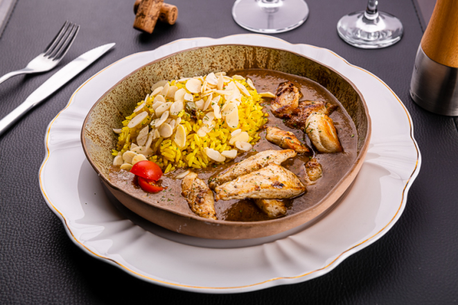 Tiras de frango ao molho de curry defumado com especiarias e arroz pilaf aromático com amêndoas, do Curry Pasta.