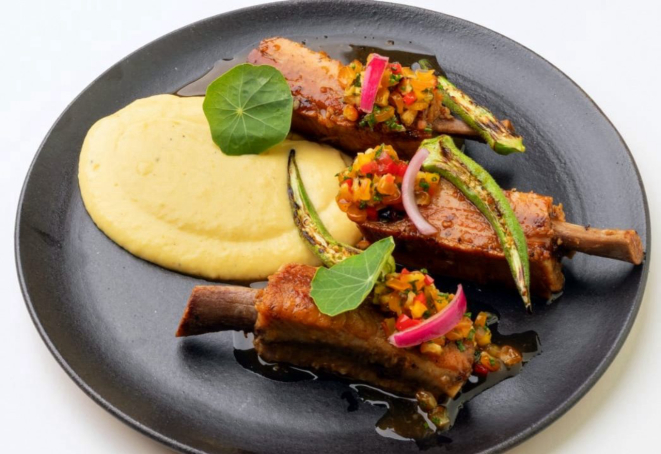 Costelinha de porco assada lentamente, servida no próprio molho, curau de milho verde, quiabo na brasa e vinagrete de milho tostado. Essa é a porção normal do menu, mas para a noite especial será um pouco reduzida, em razão da sequência de pratos.