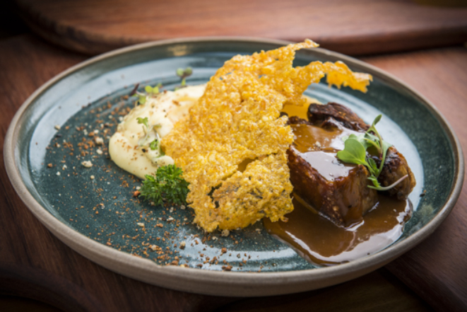 Barriga de porco em glacê de doce de leite com milho em duas texturas, do Grés Gastronomia.