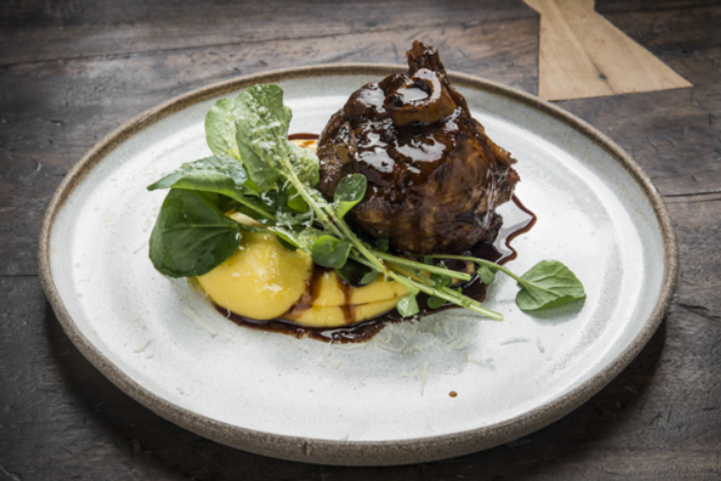 Stinco suíno com polentinha com queijo colonial, saladinha de agrião e demi-glace de porco, do Quintal do Porco.