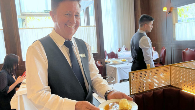 Newton Godinho, o garçom mais antigo da casa, servindo Crêpe Suzette. Ele é o criador dos dinossauros.