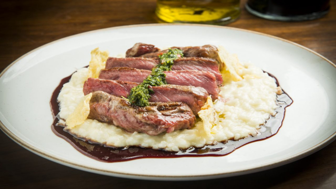 Flat Eye Steak servido com risoto porteño e redução de vinho malbec, opção de almoço e jantar do Pobre Juan.