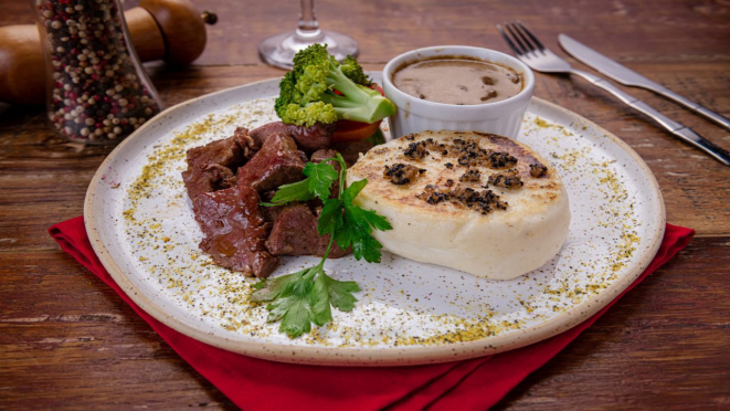 Polenta trufada ao funghi e mignon angus, polenta branca brustolada com tartufo italiano, molho funghi e lascas de mignon angus. Prato servido no almoço no Anarco Restaurante Mercado Municipal.