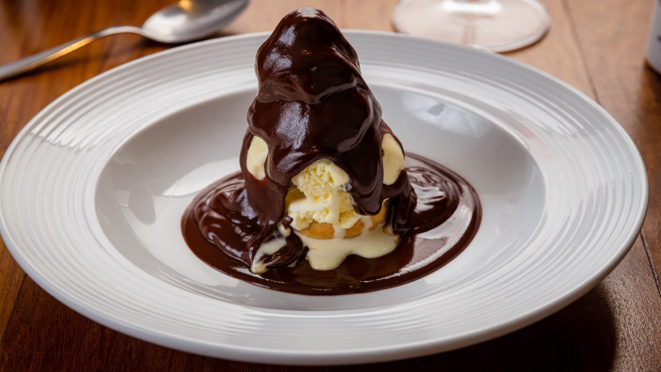 Profiteroles com sorvete, carolina recheada com sorvete de creme e calda de chocolate. Opção servida no almoço e jantar do Doppo Cucina.