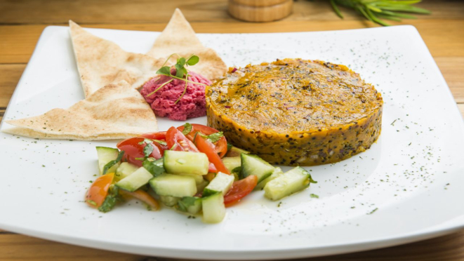 Quibe de abóbora com quinoa, que trata-se de quibe vegano de abóbora-cabotiá e mix de quinoa, recheado com cebola caramelizada. Opção oferecida no almoço e jantar do Veg e Lev.