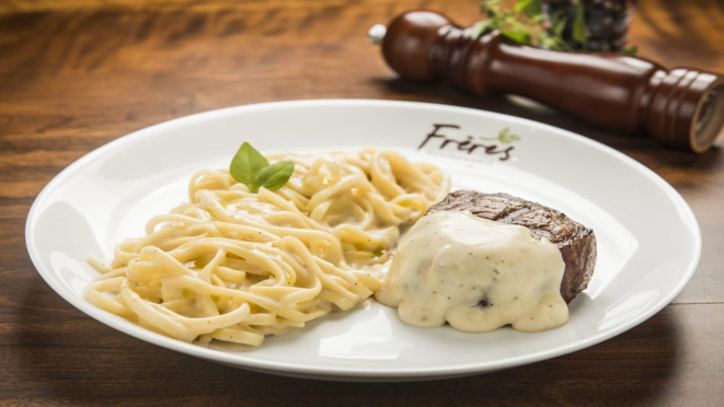 Mignon grelhado com massa aos quatro queijos, tournedor de mignon grelhado servido com massa ao molho quatro queijos. Prato principal do almoço do Frères Gastronomia.