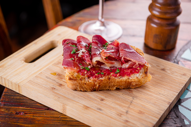 Pan tumaca com jamón (pão tostado com tomate ralado e temperado, com jamón), uma das opções de entrada do jantar do Pata Negra.