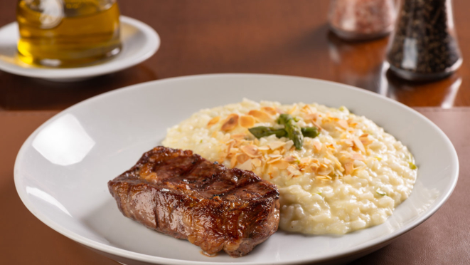 No jantar o prato principal é bife de ancho black angus uruguaio grelhado, acompanhado de risoto de aspargos frescos. O restaurante também tem outras opções com carne no menu.