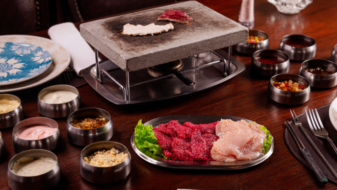 Fondue na pedra com filé mignon e frango, com 13 molhos de acompanhamento, no Château de Gazon.