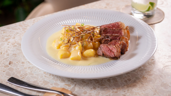 Nhoque defumado de batata salsa com bife de chorizo e crispy de alho poró. O Ninna também tem outra opção com carne no menu.