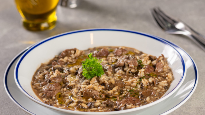 Risoto salteado com alho-poró, cogumelos frescos, acompanhado de tiras de alcatra grelhada, finalizado com parmesão ralado do Jangaroo - Fish & Meat. O restaurante tem opções com massa.