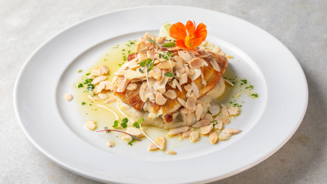 Saint Peter com manteiga queimada, amêndoas e purê de banana. O restaurante tem outras opções com frutos do mar.