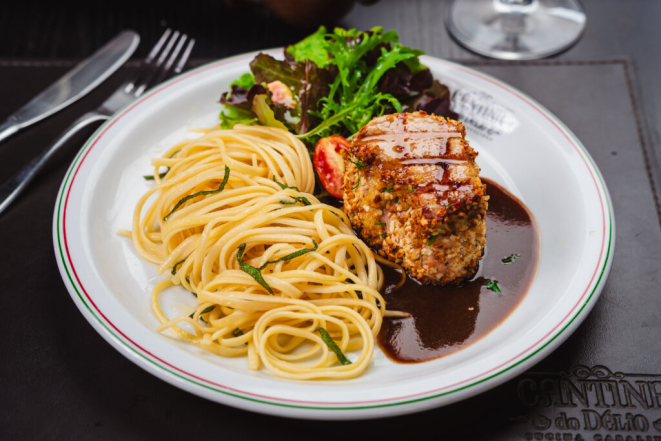 Filé mignon suíno com crosta de ervas frescas e pistache ao demi glacê guarnecido com fettucine na manteiga de sálvia, da Cantina do Délio Batel. Foto: Priscilla Fiedler