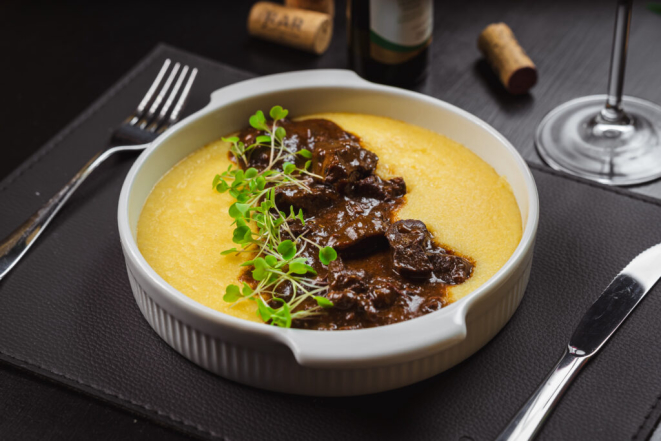 Molho com vinho Avvento Cabernet Sauvignon e cubos de carne de cordeiro, servidos com cremosa polenta italiana e queijo parmesão, do Spaccio RAR. Foto: Priscilla Fiedler