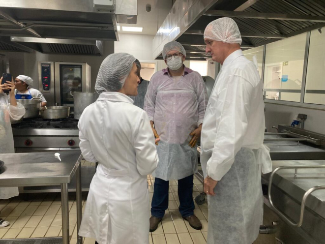 Ana Elisa Elera Negrão (à esquerda) e Fernando César de Oliveira (à direita) com Leonardo Cabral (centro) na cozinha do setor de Nutrição e Dietética do Hospital Erasto Gaertner. Foto: Bom Gourmet
