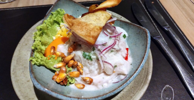 Ceviche norteño mixto (frutos do mar, camarões, lula e polvo, pimenta ají amarillo, leche de tigre, servido com couve crocante). | Foto: Anacreon de Téos