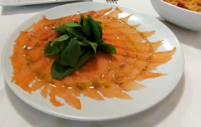 O Gravlax ganha um toque defumado e é acompanhado de chips de batata-doce crocantes. | Foto: Anacreon de Téos
