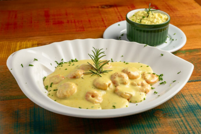 Linguado grelhado ao molho cítrico com camarões grelhados e acompanhado de Risoto de parmesão, disponível no menu do estabelecimento . Crédito: Natasha Azambuja.