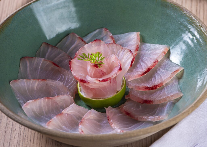 <em>Ussuzukuri </em>(finas fatias de robalo, regadas ao molho cítrico), prato elaborado por Ronaldo Fogaça para abrir evento com Ile de France e Clos de Borgeaux. | Foto: Rodrigo Pierrot