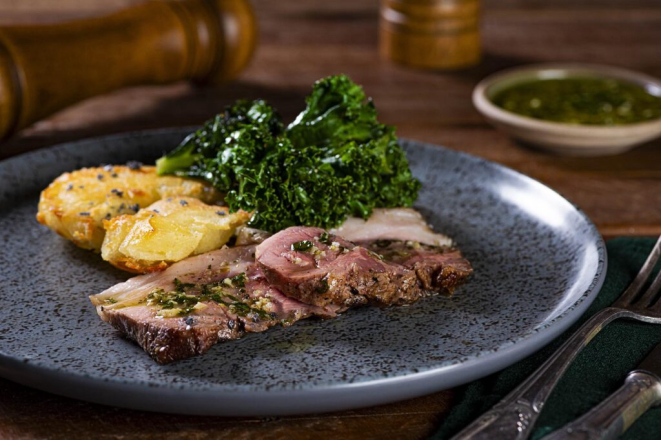 <em>Shoulder steak de porco Moura na brasa</em>, com chimichurri de erva-mate, mandioca em <em>bagna càuda</em>. | Foto: Rodrigo Pierrot