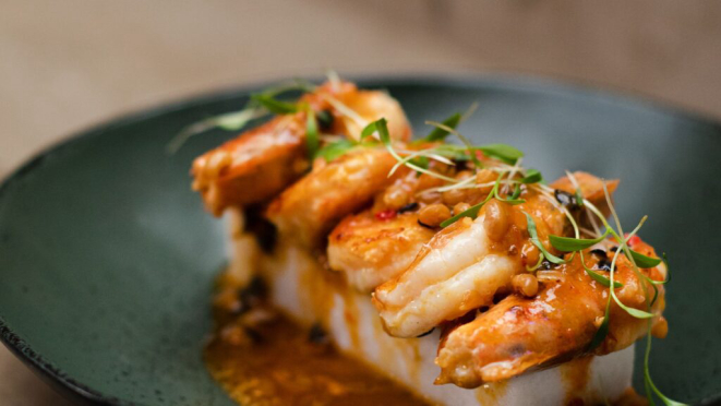 Camarão grelhado com manteiga de maracujá e acaçá deito com farinha de arroz e leite de coco, uma das atrações do menu do Irina Restaurant. Crédito: Divulgação.