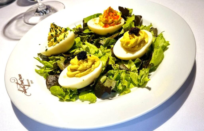 <em>Œuf mayonnaise </em>(ovos recheados com creme mayonnaise, finalizados com salsa de trufas, ovas, salsinha e páprica) - rendeu ao restaurante ser única referência brasileira em associação francesa. | Foto: Simone Meirelles (Comer & Curtir).