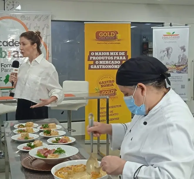 Carla Sehn apresenta o rondelli para os jurados durante o concurso O Quilo é Nosso. Ela teve o apoio da cozinheira Cintia Simeão.