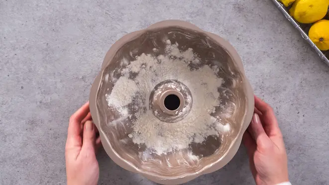 Unte e enfarinhe a forma de bolo com capricho para evitar que a massa grude.