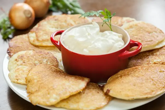 As panquecas russas Draniki são feitas de batata e cebola e acompanham molho Smetana à base de iogurte e nata fresca. Foto Fernando Zequinão / Gazeta do Povo