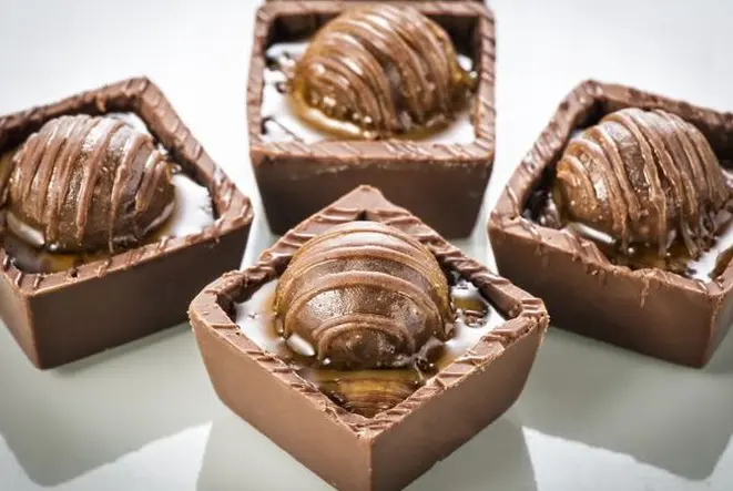 Brasileiríssimo, o doce de leite faz parte dos eleitos. Que tal brincar com texturas, como no caso do náufrago de doce de leite, composto por caixinha de chocolate belga, doce de leite e um minibrigadeiro espelhado – sugestão de Rose Marie e Simone Nejm?. Foto: Letícia Akemi/Gazeta do Povo