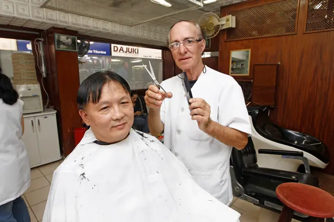 O bancário Mauro Takaso sendo atendido pelo cabeleireiro Eloir Luvizotto.