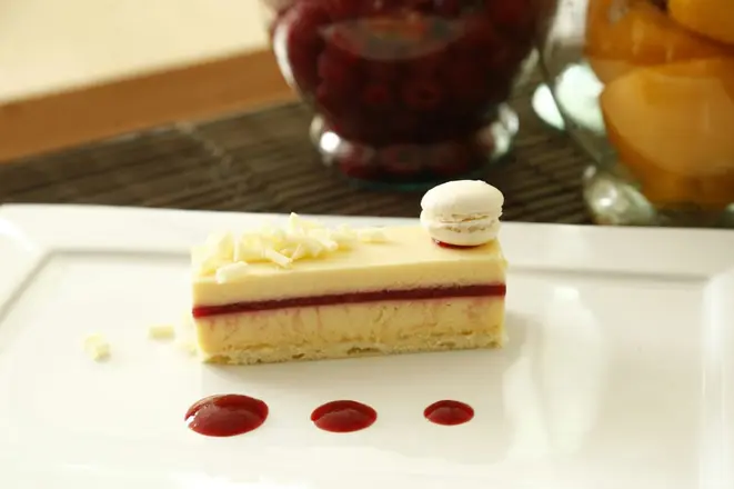 Barrinha de chocolate branco, polpa de maracujá e coulis de framboesa, servida com um minimacaron. A criação é do Bazar Doce. Foto: Hugo Harada / Gazeta do Povo