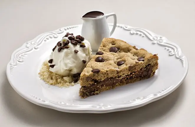 A torta cookie da Sugar Bakery não é a mais bonita do estabelecimento, mas quando recebe a calda de chocolate, esta "gordice" vira sucesso nas redes. Foto: Alexandre Mazzo/Gazeta do Povo