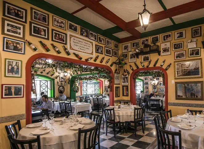 As paredes do Lellis Trattoria são repletas de fotos dos clientes mais assíduos. Foto: Letícia Akemi/Gazeta do Povo.